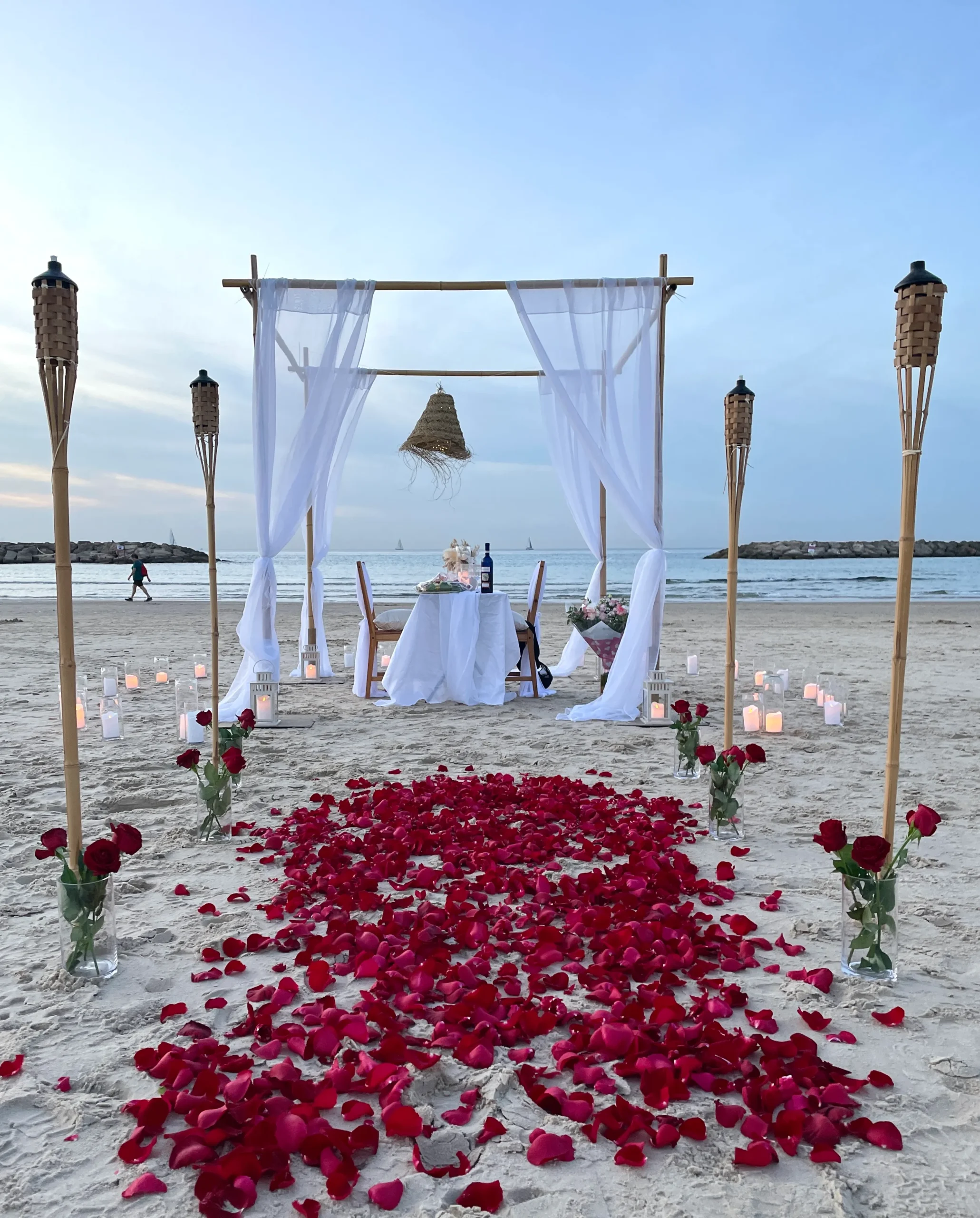 הצעת נישואין בסגנון ארוחה זוגית רומנטית - המשלבת עמדת במבוק בצורת חופה עם בדים, אהילים ועששיות. בנוסף פינת ישיבה מלאה הכוללת שולחן וכיסאות , עריכת שולחן, אביזרי נוי משלימים וורדים טריים לשדרוג העיצוב. עיצוב מושלם להצעת נישואין באווירה חמימה, מפנקת וקסומה !