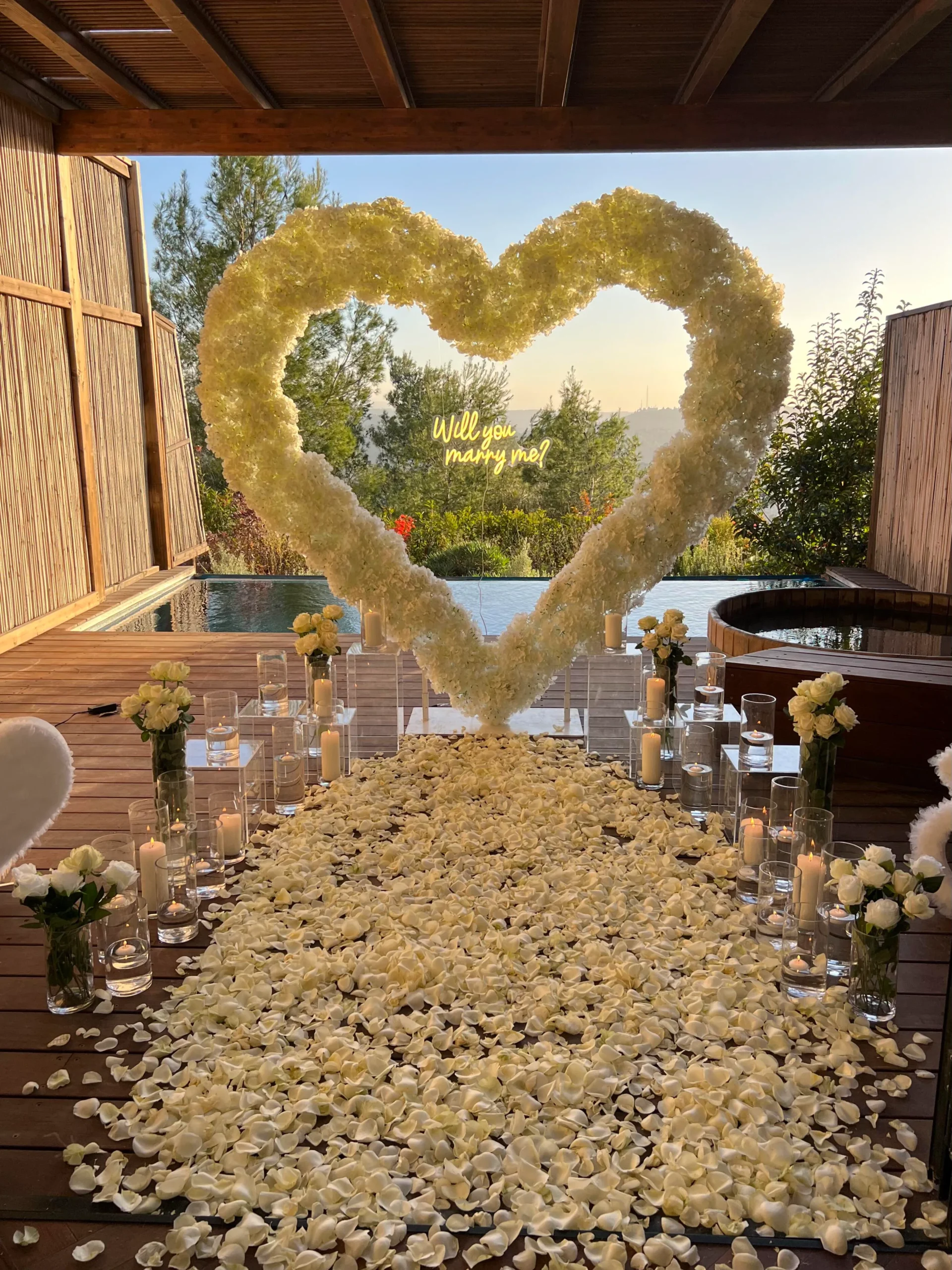 הצעת נישואין קלאסית ורומנטית המשלבת עיצוב מוקפד וייחודי וורדים חיים ליצירת האווירה המושלמת - מעמד בצורת לב ייחודי , שלט לד בכיתוב "will you marry me?" , וואזות , נרות ופרחים. עיצוב מושלם לחללים אינטימיים ומרווחים כאחד.