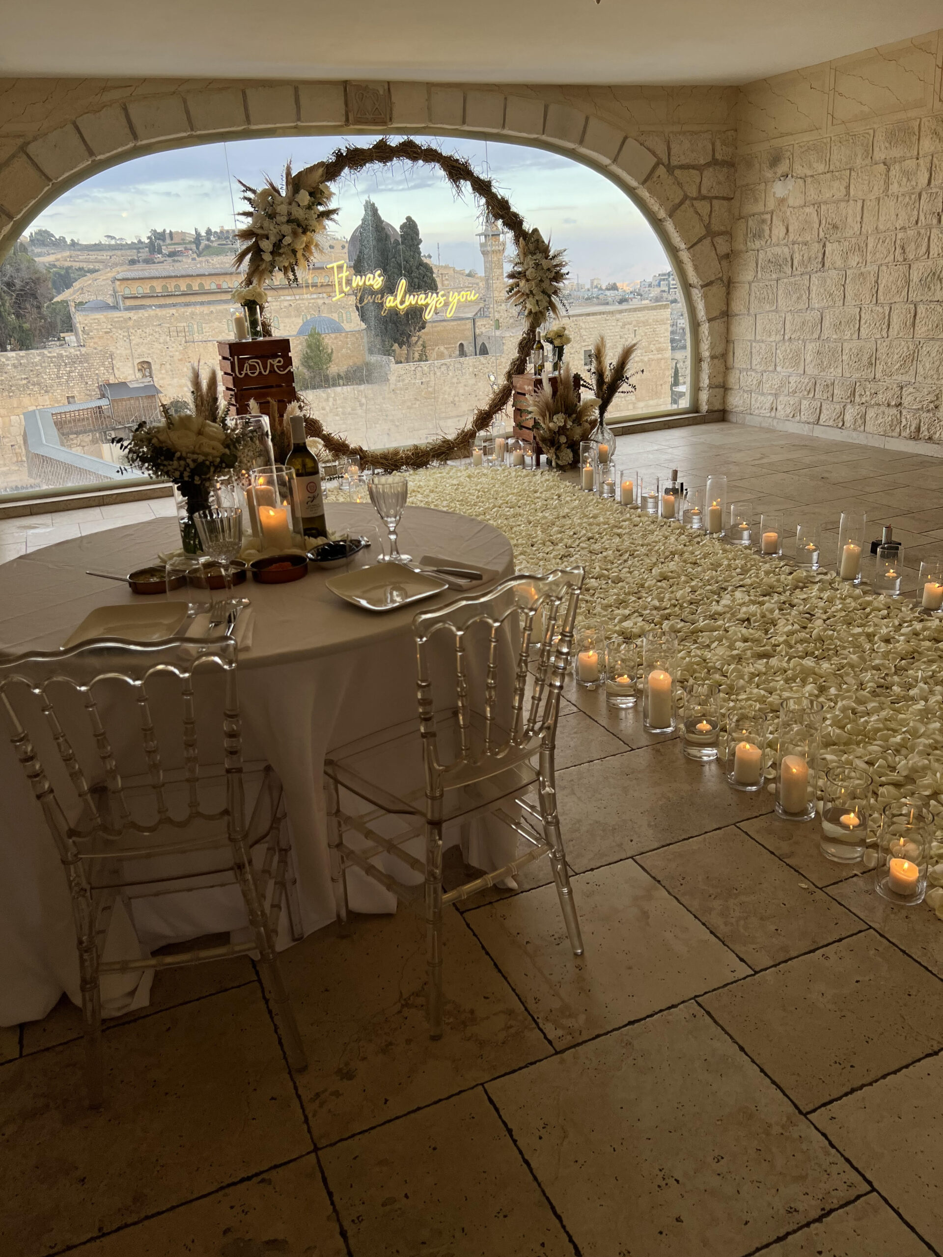 הצעת נישואין חלומית המשלבת מאות ורדים אמיתיים, נרות, וואזות זכוכית וזוג צועד על שביל של אהבה. עמדת עיגול בוהו עם זרי פרחים מרהיבים העשויים עבודת יד ושלט מואר וייחודי בכיתוב "It was always you" – לרגע אחד שהוא לנצח.