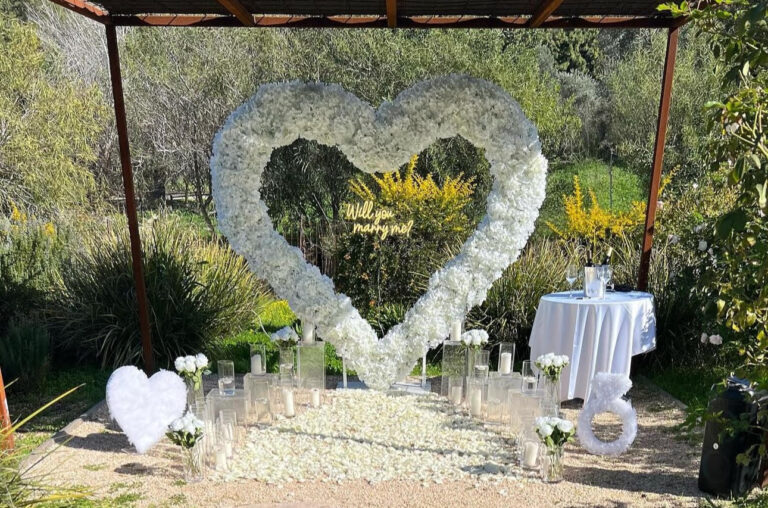 הצעת נישואין קלאסית ורומנטית המשלבת עיצוב מוקפד וייחודי וורדים חיים ליצירת האווירה המושלמת - מעמד בצורת לב ייחודי , שלט לד בכיתוב "will you marry me?" , וואזות , נרות ופרחים. עיצוב מושלם לחללים אינטימיים ומרווחים כאחד.