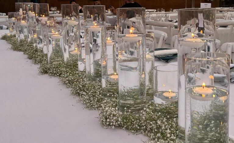 שולחן אבירים לחתונה בסגנון קלאסי ויוקרתי, מעוצב בוואזות זכוכית , נרות צפים ושזירת גיבסניות לכל אורכו