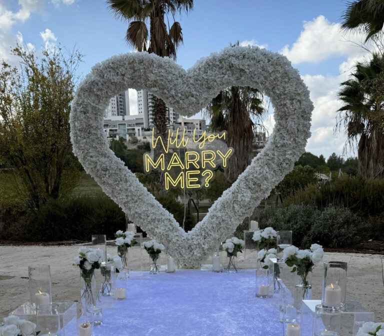 הצעת נישואין קלאסית ורומנטית - מעמד בצורת לב ייחודי , שלט לד בכיתוב "will you marry me?" , וואזות , נרות ופרחים. עיצוב מושלם לחללים אינטימיים ומרווחים כאחד.