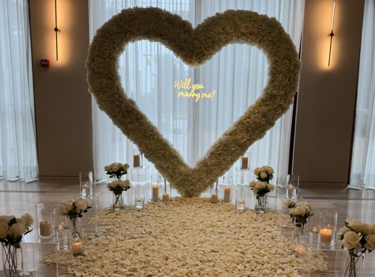 הצעת נישואין קלאסית ורומנטית המשלבת עיצוב מוקפד וייחודי וורדים חיים ליצירת האווירה המושלמת - מעמד בצורת לב ייחודי , שלט לד בכיתוב "will you marry me?" , וואזות , נרות ופרחים. עיצוב מושלם לחללים אינטימיים ומרווחים כאחד.